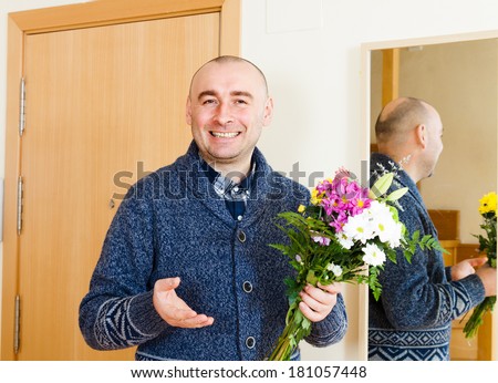 Joyful man with  beautiful bouquet near  front door