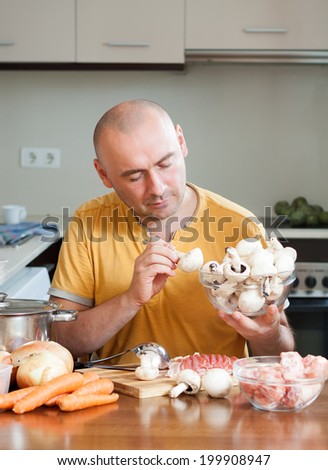 Chef man in orange t-shirt in the kitchen