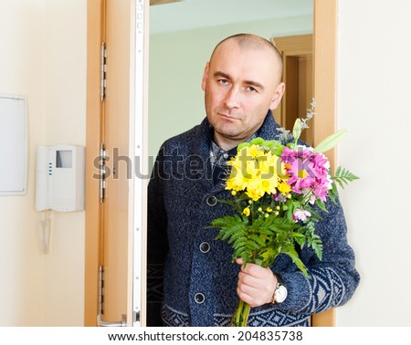 guilty man asks forgiveness with  bouquet of flowers.
