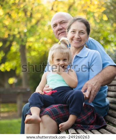 Portrait of grandma and  grandpa with little grandaughter outdoor