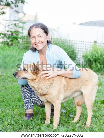 Beautiful woman in   age of   dog on   lawn.