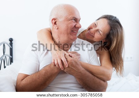 Mature man and woman on   bed in   bedroom.