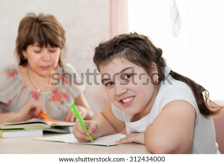 Mom and daughter doing homework at home.