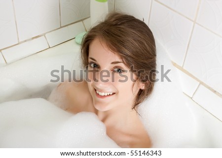 young beautiful girl in a bath with  foam