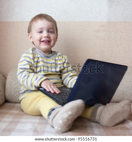 Smiling child playing with blue laptop