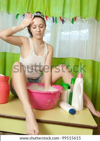 Sexy housewife washes clothes in a basin
