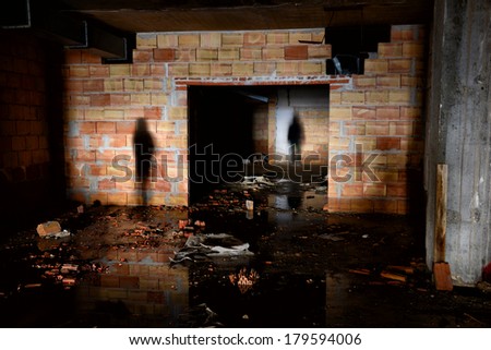 Silhouettes of people moving in an abandoned building.