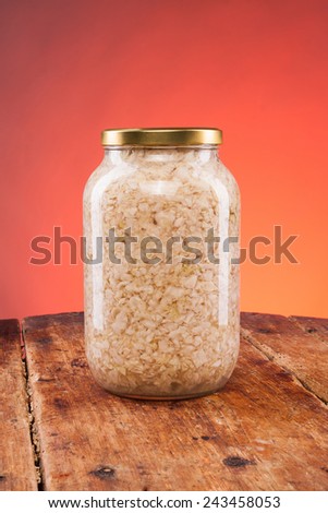 Salad jar on a wooden table with red background