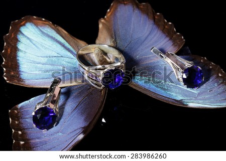 Beautiful gold ring and earrings with blue gemstones on a butterfly wings.