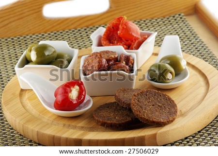 Platter with tapas, olives, pepper, sausages & tomatoes