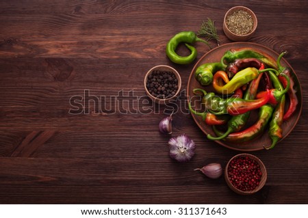 Hot peppers and spices on a dark wooden background; Hot peppers; ingredients for cooking; cover cookbook