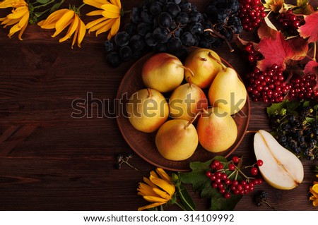 Fresh juicy pear; Pears on clay plate; autumn still life; Autumn background; Cover for the fall menu; grapes; heather; autumn grass and fruit on wooden background;  substrate for the menu; cookbook;