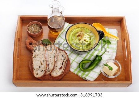 Low-calorie soup broccoli puree on the plate; lunch of soup and bread on a tray; green soup on a tray; White background; healthy eating; hipsters; reset weight; smoothies