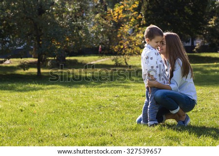 Mother kissing and hugging her son in park