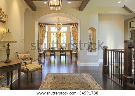 Grand foyer with area rug and view to dining room