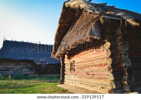 Old wooden house in the Ukrainian village. The traditional housing for the residents of the Ukrainian village. The roof is made of straw