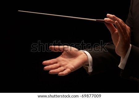 Conductor conducting an orchestra isolated on black background