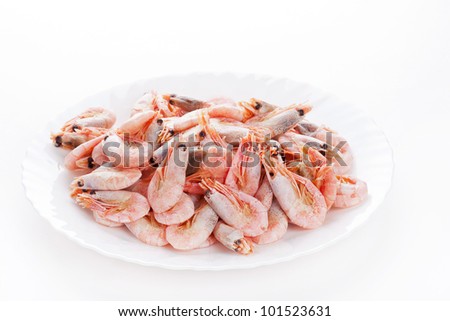Pile of frozen shrimps on plate, closeup on white background