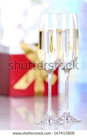 Pair glasses of champagne and present box, closeup