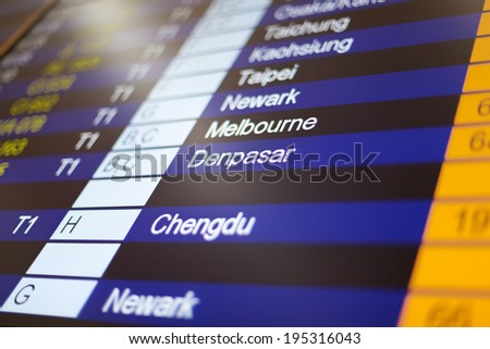 Airport arrival board in airport terminal. Travel concept. Denpasar in focus.