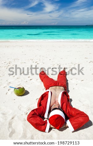 Santa Claus on beach relaxing, enjoying summer