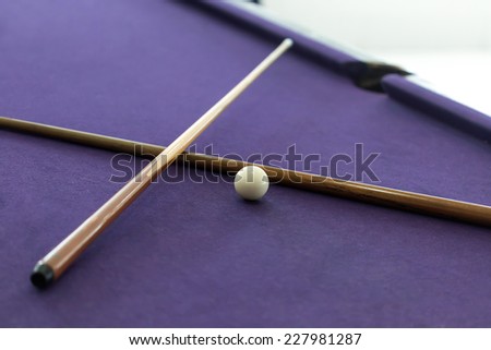 Billiard cues and white ball in pool table