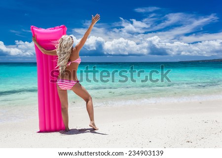 Woman with pink swimming mattress on tropical beach, Philippines, Boracay