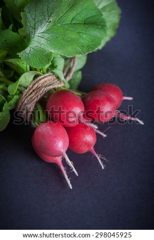 Bunch of ripe red radish on black background, selective focus and shallow depth