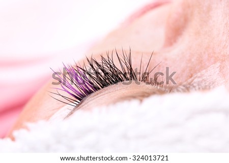 Lash making process, extreme long lashes with closed eye, woman eyelash extension. Macro shot, shallow depth