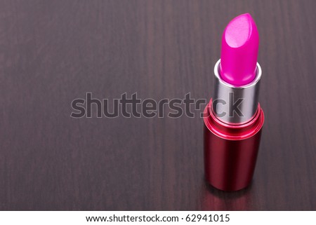 Pink lipstick on black table, closed-up