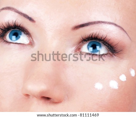 Girl with cream for eyes area on face, portrait