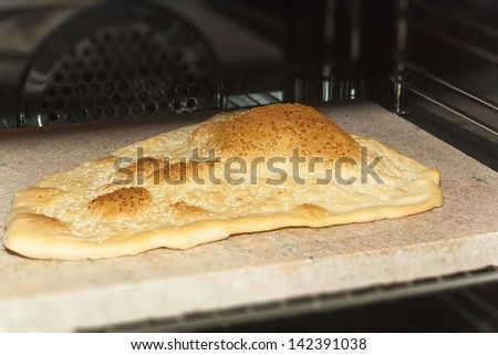 Eastern bread baking in oven on a stone
