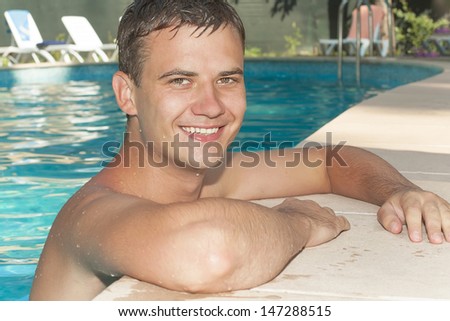 handsome guy leaned on the side of the pool