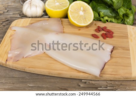 raw squid on a cutting Board on the table from the old boards