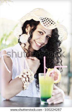 young lady with cocktail on the beach