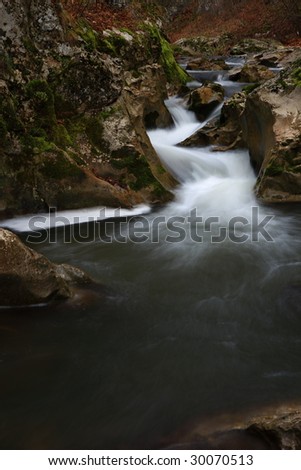 Forest stream running over mossy rocks from wild nature East Europe