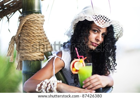 portrait of the beauty lady with cocktail on the bar to the beach