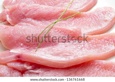 some slices of raw turkey meat on a white background