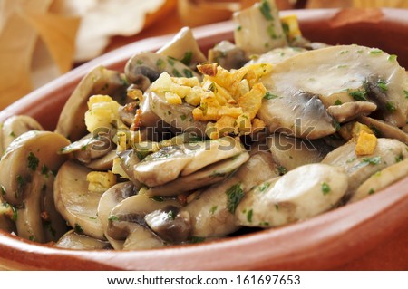 cooked mushrooms with garlic and parsley in an earthenware bowl
