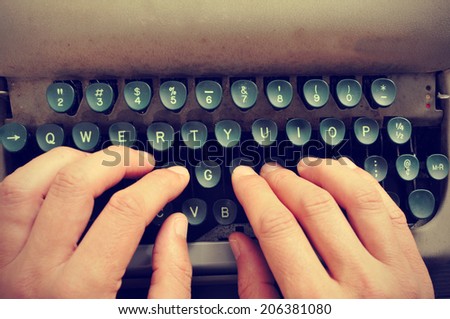 closeup of the hands of a man typing on an old typewriter