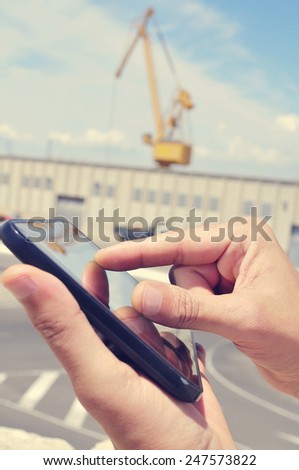 closeup of the hands of a man using a tablet in an industrial park