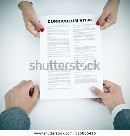 closeup of a young woman and a young man with a curriculum vitae in their hands
