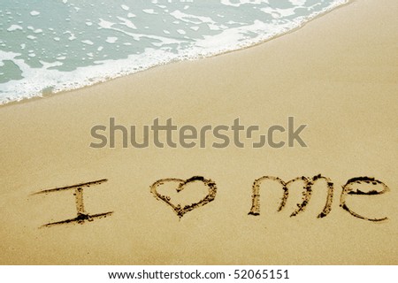 i love me written on the sand of a beach
