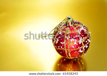 red and golden christmas ball with snowflakes on a golden background