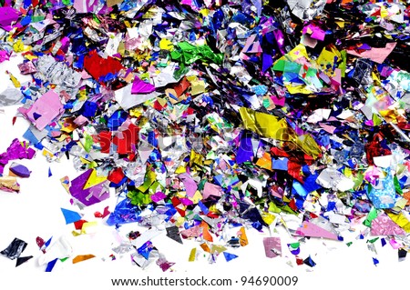 a pile of metallic confetti of different colors on a white background