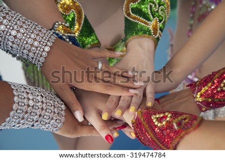Stack of hands joining in unity. Close up of women dancers supporting each other.