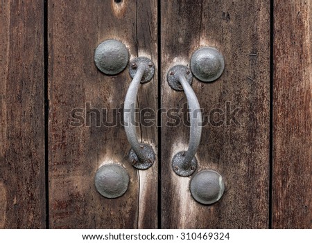 Old weather wooden door with rusty metal door handles,  Medieval