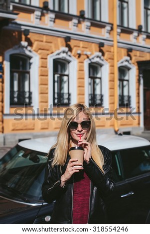 Girl with coffee on the background of cars and houses