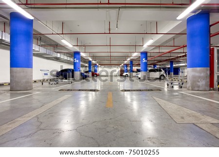 Parking garage, underground interior with a few parked cars