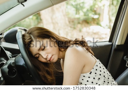 Portrait of an Asian woman feeling tired from driving for a long time, so she fell asleep at her steering wheel, safe driving concept Foto d'archivio © 